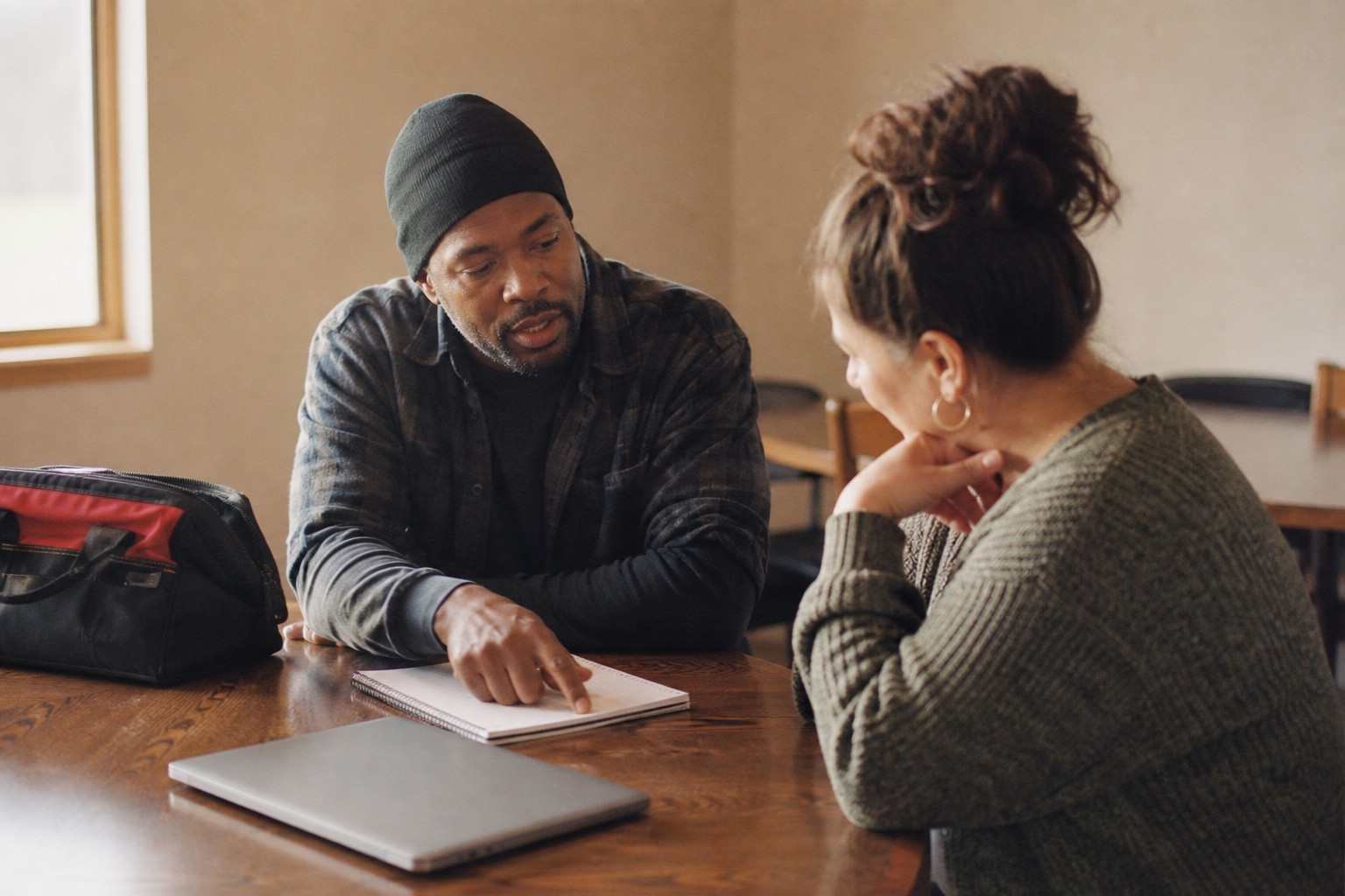 Two adults discussing notes at a table.